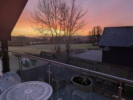 A balcony view overlooking a field and trees at Meadow Retreat in Wadebridge