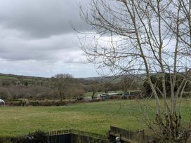 A view of a field with a tree and distant hills at Meadow Retreat in Wadebridge