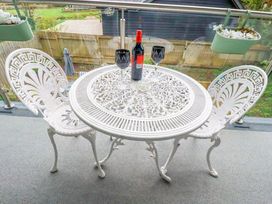 A table with wine and glasses on a balcony at Meadow Retreat in Wadebridge