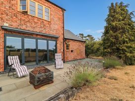 An outdoor area with reclining chairs and a fire pit at Hazeldene near Harvington