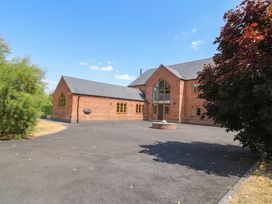 A house with a large driveway and surrounding trees at Hazeldene near Harvington