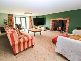 A living room with a fireplace and a television at Hazeldene near Harvington