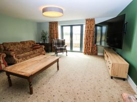 A living room with a sofa, armchair and coffee table at Hazeldene near Harvington
