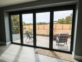 A view of a patio with chairs through sliding doors at Hazeldene near Harvington