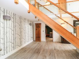 A hallway with a staircase and wooden cabinet at Hazeldene near Harvington