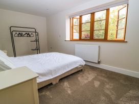 A bedroom with a bed and clothes rack at Hazeldene near Harvington