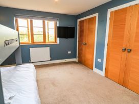A bedroom with a bed, television, and window at Hazeldene near Harvington