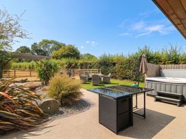 A garden with a table and hot tub at Hazeldene near Harvington