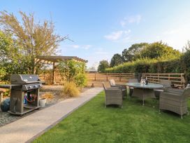 A garden with a grill and seating area at Hazeldene near Harvington