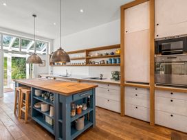 A kitchen with an island and shelves at Chantry Studio in Kingsbridge