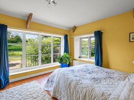 A bedroom with a bed and windows at Chantry Studio in Kingsbridge