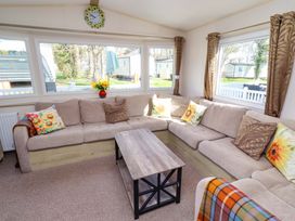 A living room with a sofa and coffee table at Sunflower Retreat, Caravan 61