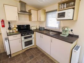 A kitchen with appliances and cabinets at Sunflower Retreat, Caravan 61