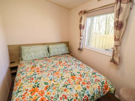 A bedroom with a bed and window at Sunflower Retreat, Caravan 61
