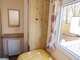 A bedroom with a bed and wardrobe at Sunflower Retreat, Caravan 61