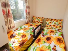 A bedroom with two beds and a window at Sunflower Retreat, Caravan 61