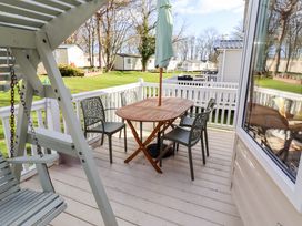 An outdoor seating area with a table and chairs at Sunflower Retreat, Caravan 61