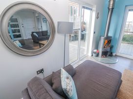 A living room with a sofa and wood stove at Warleggan in Redruth
