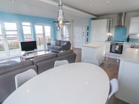 A living room with a sofa and kitchen area at Warleggan in Redruth