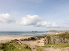 A beach with people and rocks at Warleggan in Portreath