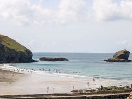 A beach scene with people swimming and walking at Warleggan in Portreath