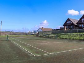 A tennis court with buildings in the background at Warleggan, Portreath