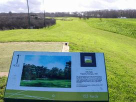 A golf course hole view with a sign at The Famous Nine in Portreath
