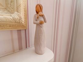 A figurine on a shelf next to a framed picture at Annie's Place in Sleights