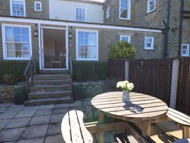 A garden with a wooden table and potted plants at Annie's Place in Sleights