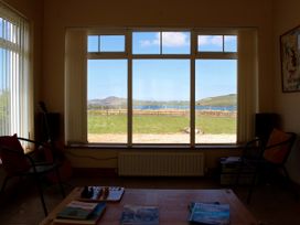 A living room with a guitar and a view of mountains and water at Welcome to the wild Atlantic way Mulroy Bay