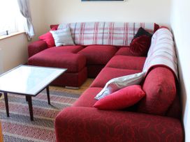 A living room with a red sofa and a coffee table at Welcome to the wild Atlantic way, Mulroy Bay