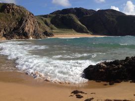 A beach with cliffs and waves at Welcome to the wild Atlantic way Mulroy Bay