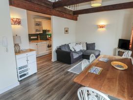 A living room with a sofa and dining table at Apartment 6 in Penryn
