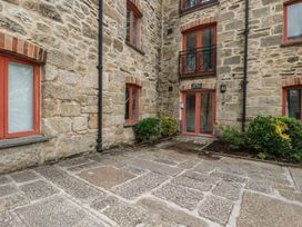 An outdoor area with stone wall and pathway at Daniel’s Sail Loft Penthouse in Penryn