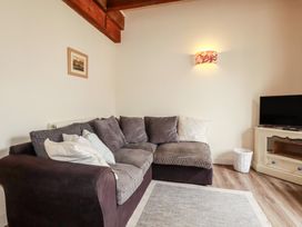 A living room with a sofa and TV at Daniel’s Sail Loft Penthouse in Penryn