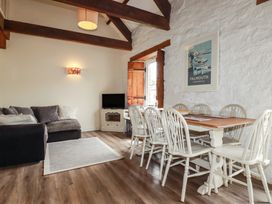 A living room with a sofa, dining table and chairs at Daniel’s Sail Loft Penthouse in Penryn