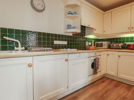 A kitchen with cabinets and appliances at Daniel’s Sail Loft Penthouse in Penryn