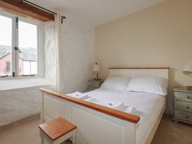 A bedroom with a bed and nightstands at Daniel’s Sail Loft Penthouse in Penryn