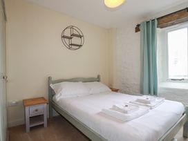 A bedroom with a bed and nightstand at Daniel’s Sail Loft Penthouse in Penryn