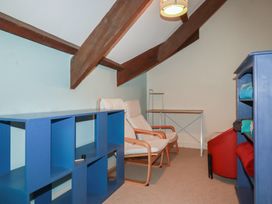 A room with a shelf, armchairs and a table at Daniel’s Sail Loft Penthouse in Penryn