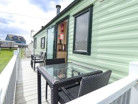 An outdoor area with chairs and a table at The Seafront Cosy Caravan in Ingoldmells