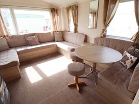 A living room with a round table and sofa at The Seafront Cosy Caravan Ingoldmells