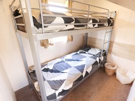 A bunk bed with bedding in a bedroom at The Seafront Cosy Caravan in Ingoldmells