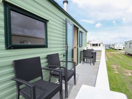 An outdoor seating area with chairs and a table at The Seafront Cosy Caravan in Ingoldmells