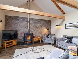 A living room with a fireplace and television at Cider Press Cottage in Torpoint