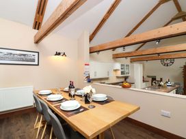 A dining area with a table set for dinner at Cider Press Cottage in Torpoint