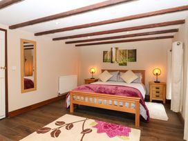 A bedroom with a bed and bedside tables at Cider Press Cottage in Torpoint