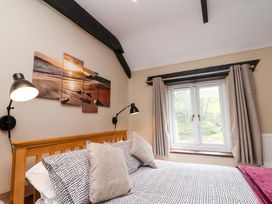 A bedroom with a bed and wall art at Cider Press Cottage in Torpoint