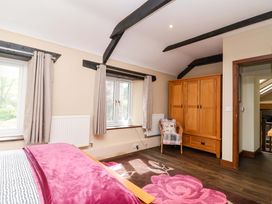 A bedroom with a bed and wardrobe at Cider Press Cottage in Torpoint