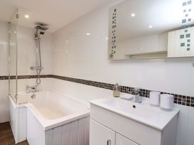 A bathroom with a bathtub and sink at Cider Press Cottage in Torpoint